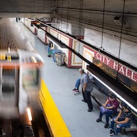 Travelers wait for the train at the South City Hall station.